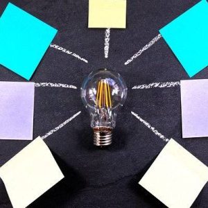 An image of a light bulb surrounded by post-it notes. This can be used to represent ideas.